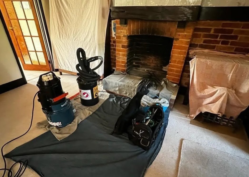 Professional sweep equipment set up at a fireplace with dust sheets